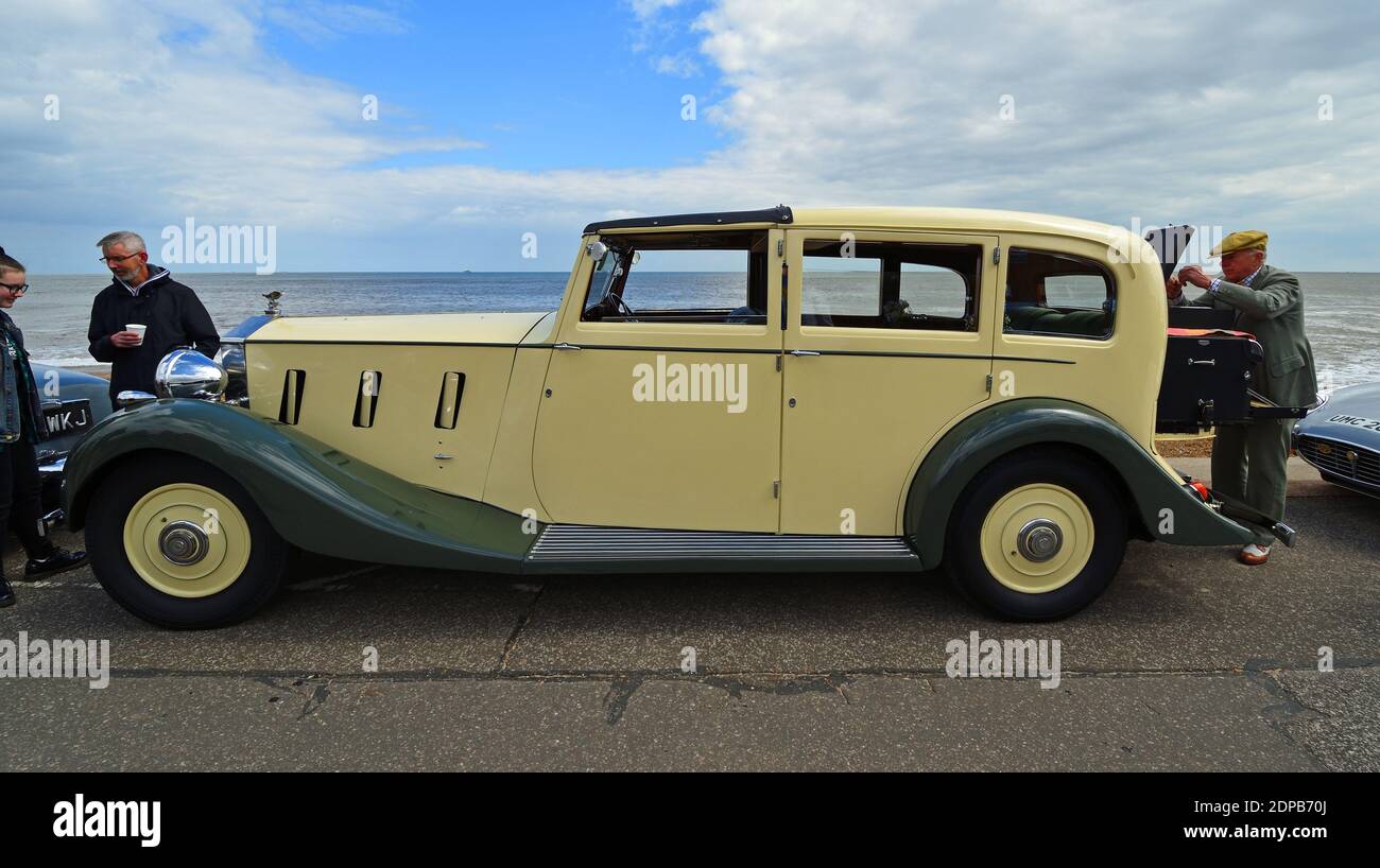 Bella panna colorata Classic Rolls Royce Motor Car parcheggiata sul lungomare con spiaggia e mare sullo sfondo. Foto Stock