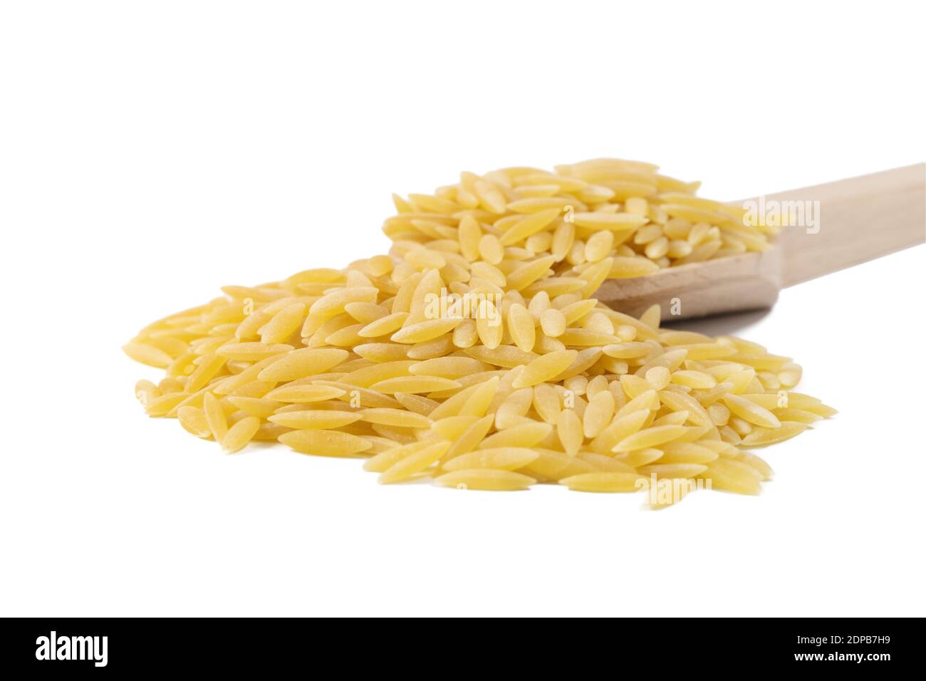 In Grecia chiamato kritharaki. In Italia si chiama Orzo. Pasta a forma di riso in cucchiaio di legno isolato su sfondo bianco. Tipo di pasta. Ingrediente alimentare. Foto Stock