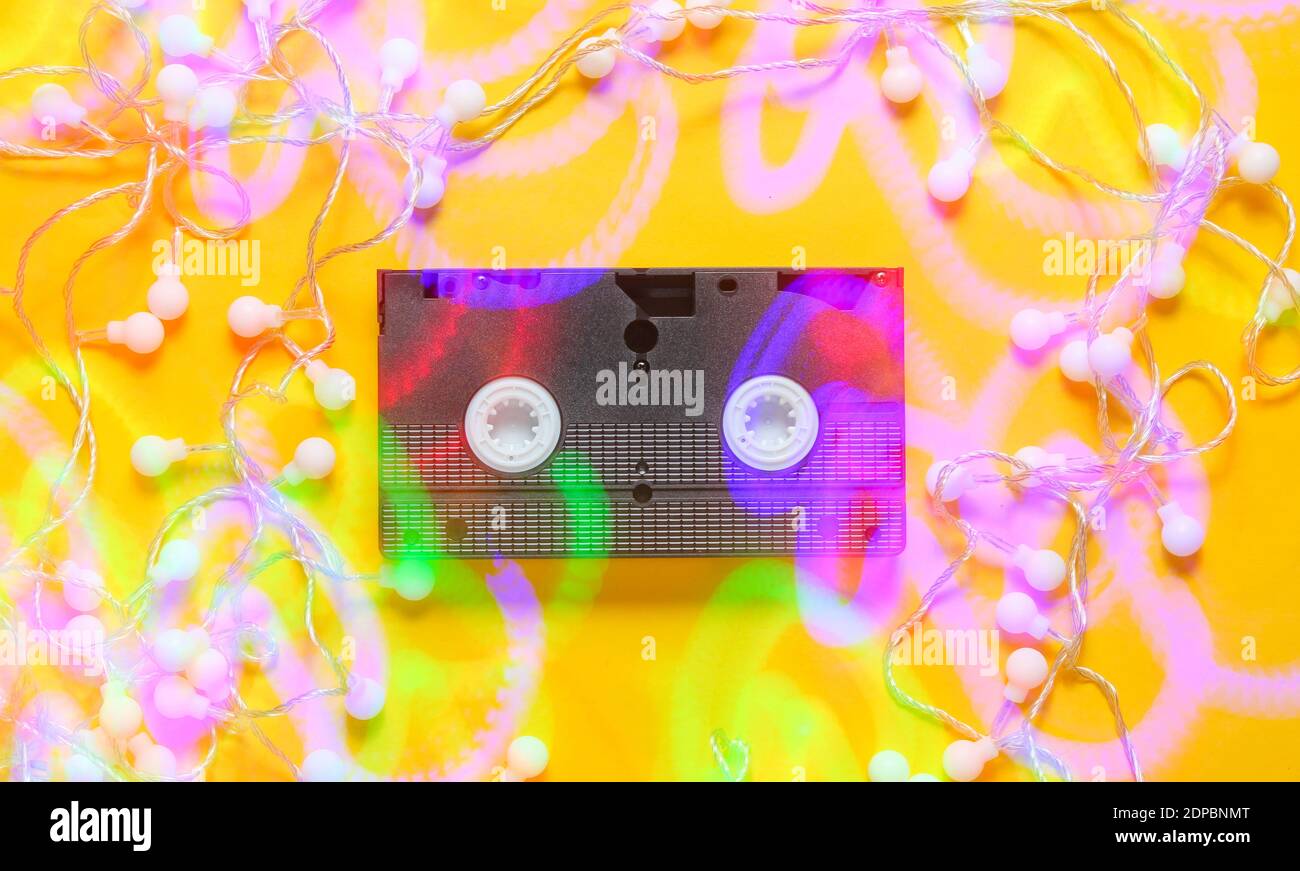 Nastro video vhs retro con LED luminosi su sfondo giallo. Effetto luce Vista dall'alto, minimalismo Foto Stock
