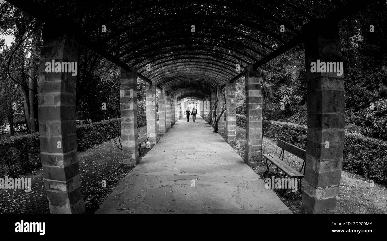 Tunnel bianco e nero e due persone che camminano verso l'ignoto. Foto Stock