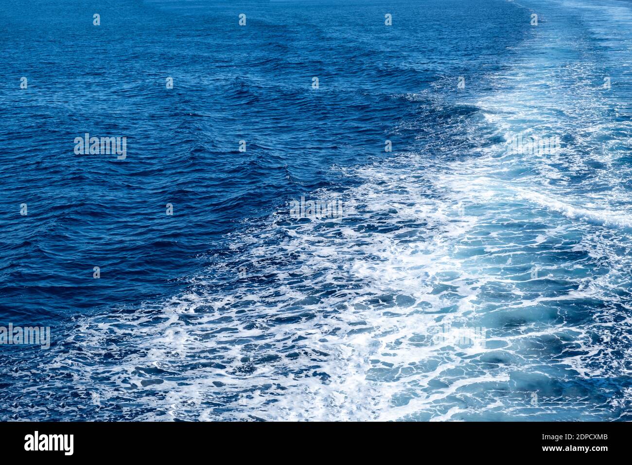 Barca bianca wake, su sfondo blu mare, vista dalla nave. Crociera sul mare Mediterraneo, concetto di vacanza estiva delle isole greche Foto Stock