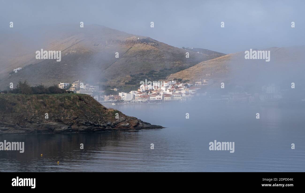 Isola di Kea Tzia, Cicladi, Grecia. Nebbia, nebbia mattutina sugli edifici del villaggio di Korissia, porto dell'isola Foto Stock