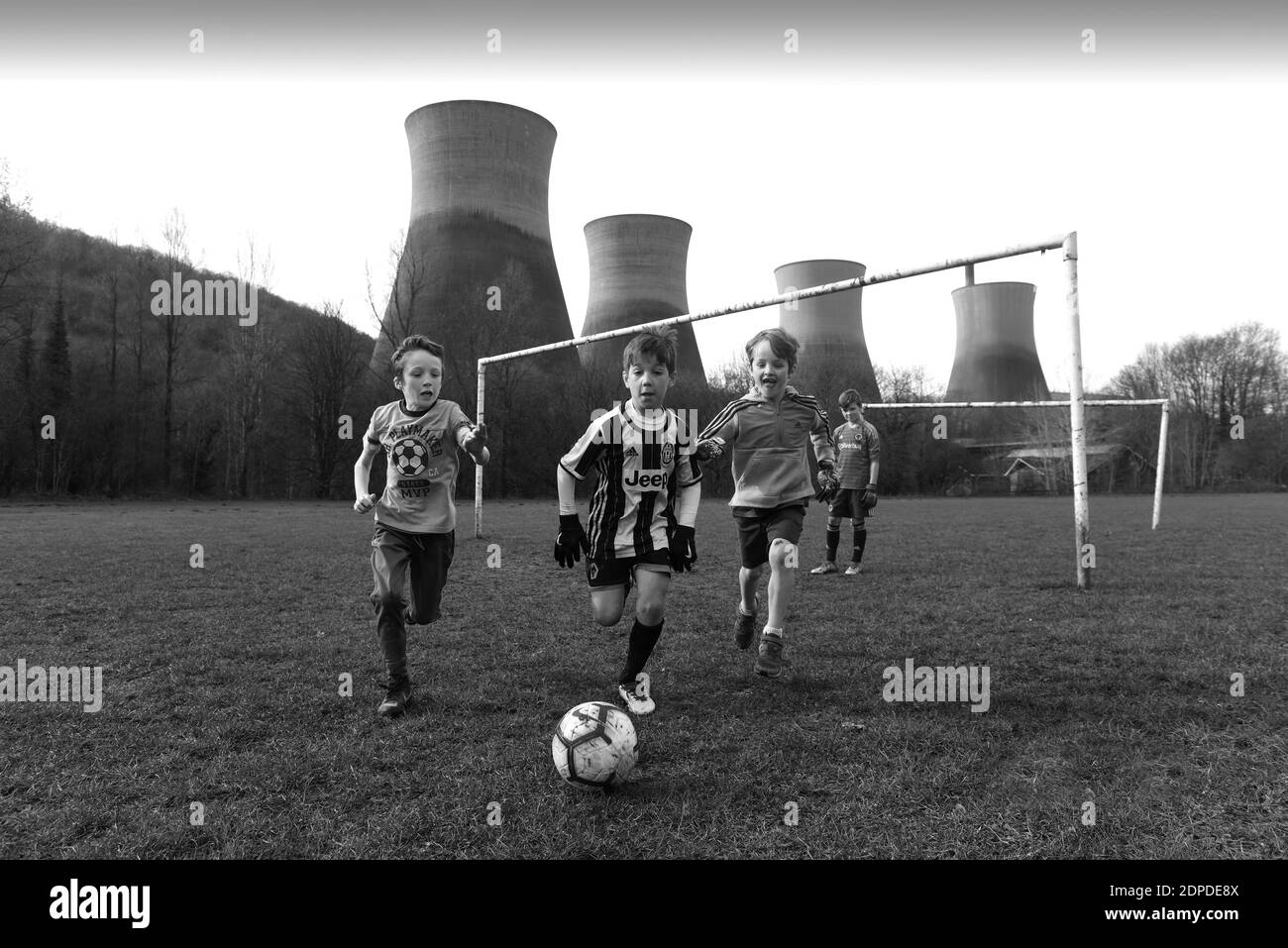 Ragazzi che giocano a calcio vicino alla centrale elettrica di Ironbridge torri di raffreddamento 2019 Foto di DAVID BAGNALL Foto Stock