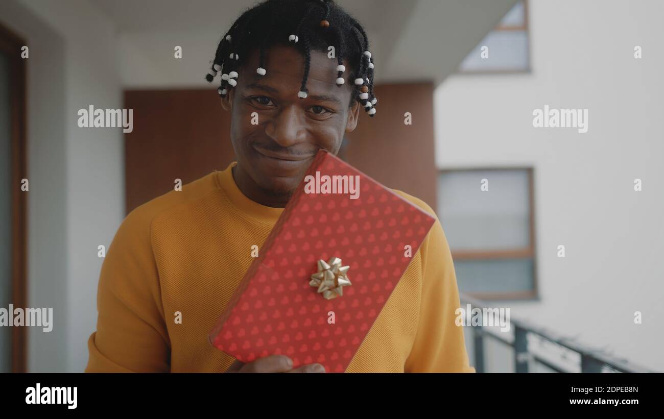 Ritratto dell'uomo nero afroamericano che tiene il regalo di natale. Foto di alta qualità Foto Stock