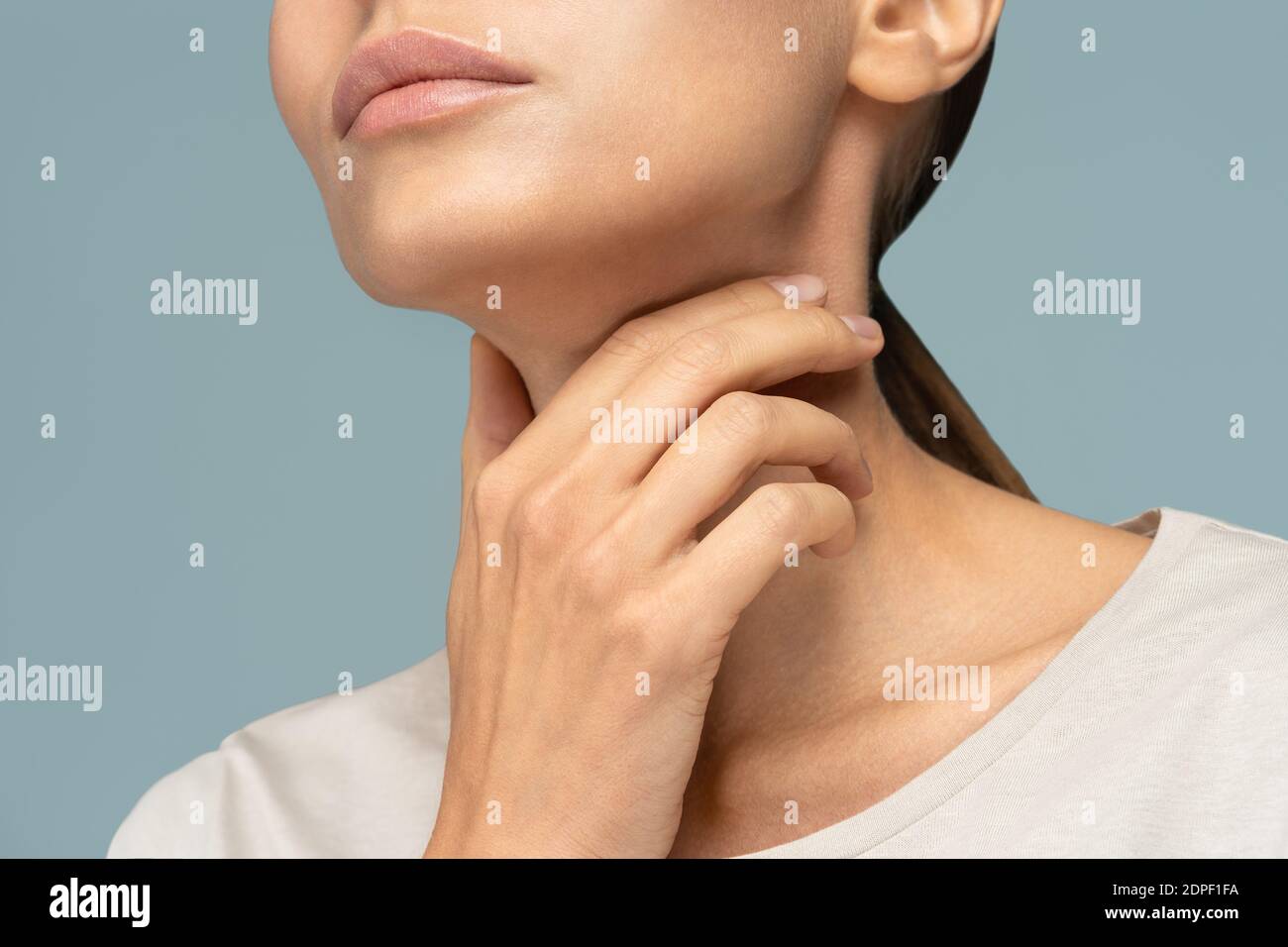 Closeup di una donna malata che ha mal di gola, tonsillite, sensazione di malessere, colto freddo, che soffre di deglutizione dolorosa, forte dolore alla gola, tenuta ha Foto Stock