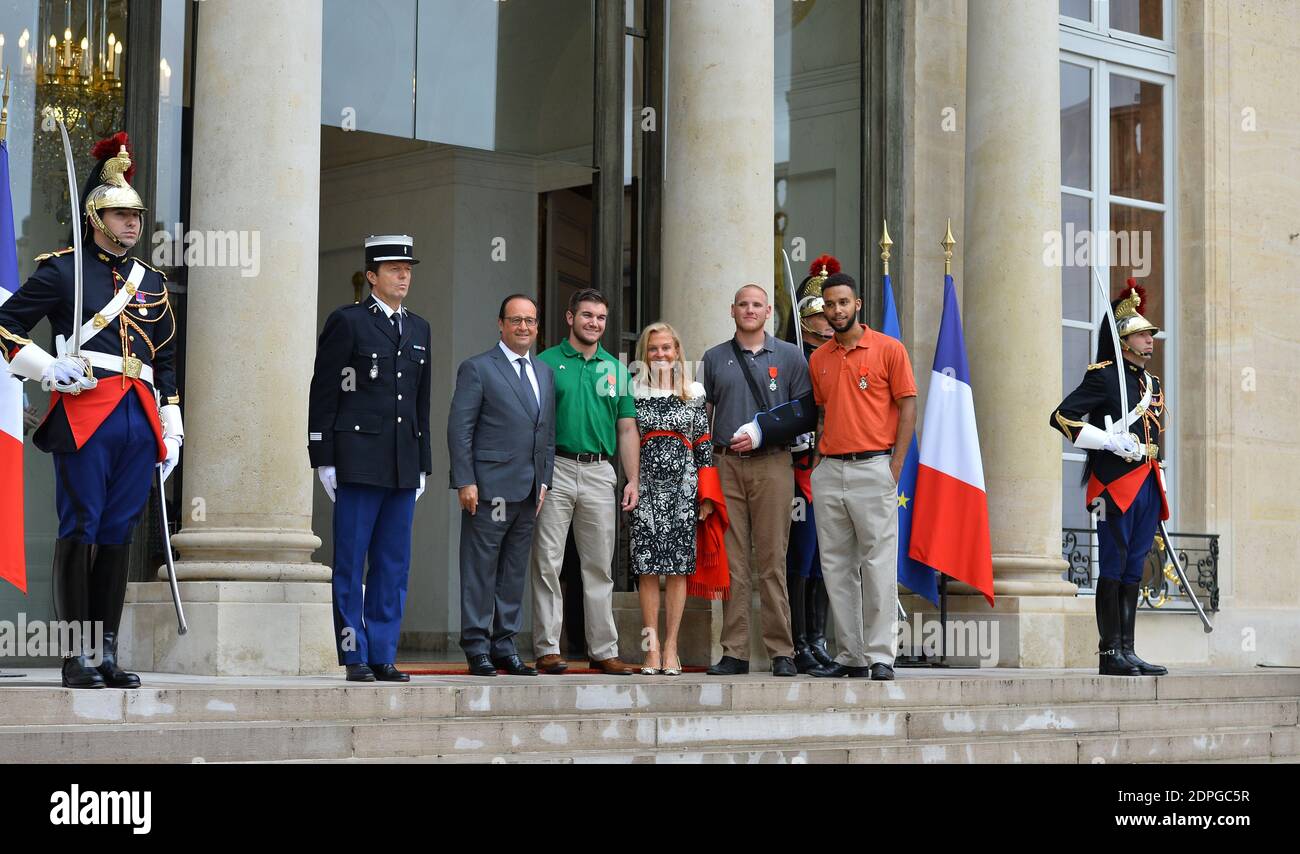 Il presidente francese Francois Hollande (L) si pone con gli americani Alek Skarlatos (II L), Spencer Stone (II R) e Anthony Sandler (L), e l'ambasciatore degli Stati Uniti in Francia Jane D. Hartley (C) dopo una cerimonia in loro onore al Palazzo Elysee, a Parigi, Francia, il 24 agosto 2015. I tre amici americani e il britannico Chris Norman hanno ricevuto la medaglia Legione d'onore per il coraggio. Hanno impedito un massacro a bordo di un treno ad alta velocità Thalys durante il tragitto per Parigi da Amsterdam venerdì, quando un artigliere marocchino fortemente armato noto come Ayoub El Khazzani ha aperto il fuoco. Foto di Christian Liegi/ABACAPRESS.C. Foto Stock