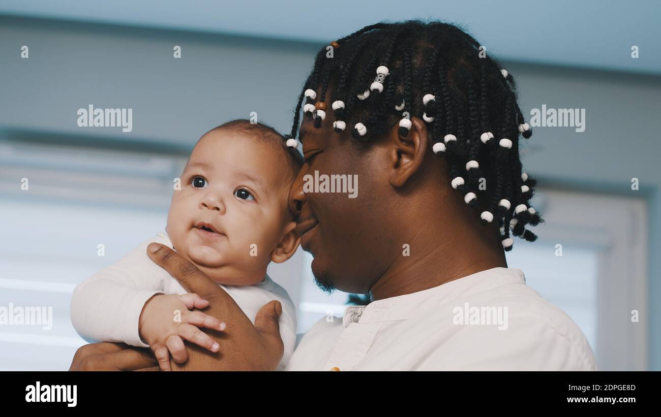Tempo di Natale in famiglia multirazziale. Il padre nero afroamericano che tiene il suo bambino mulatto. Foto di alta qualità Foto Stock