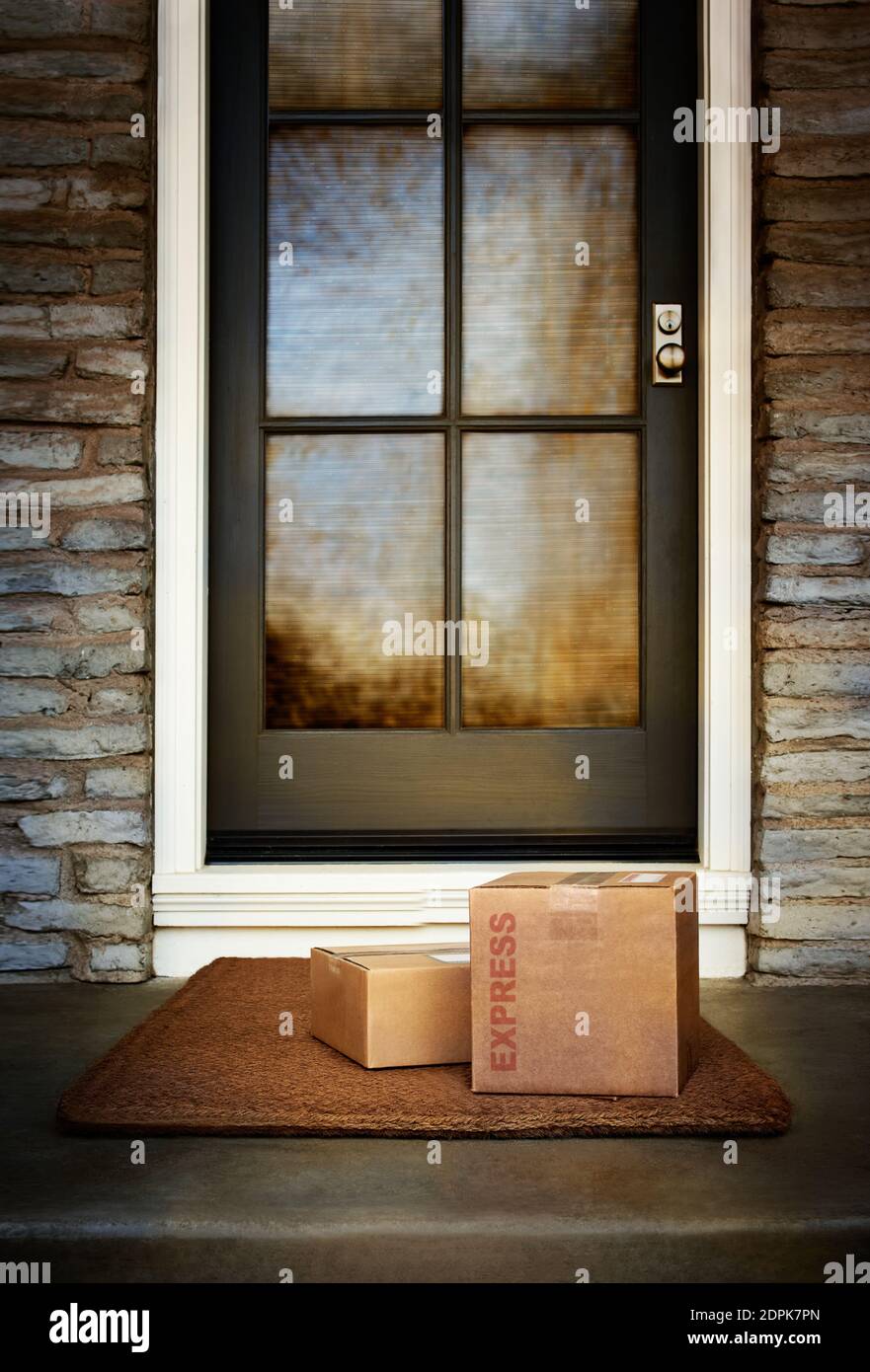 Le scatole di consegna express durante la notte sono all'esterno della porta di casa. Spazio di copia. Foto Stock