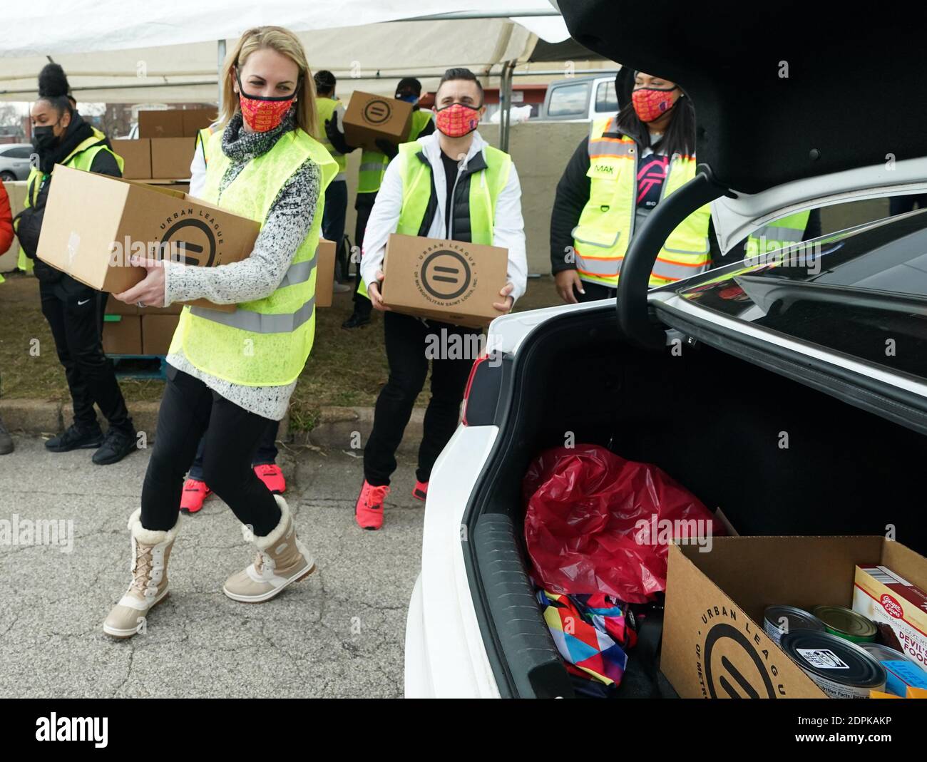 St. Louis, Stati Uniti. 19 dicembre 2020. Carolyn Kindle Betz, il proprietario principale della squadra di calcio della St. Louis SC Major League, mette una scatola di cibo in un'auto, durante il give-a-way del cibo di Natale della Urban League a St. Louis sabato 19 dicembre 2020. Photo by Bill Greenblatt/UPI Credit: UPI/Alamy Live News Foto Stock