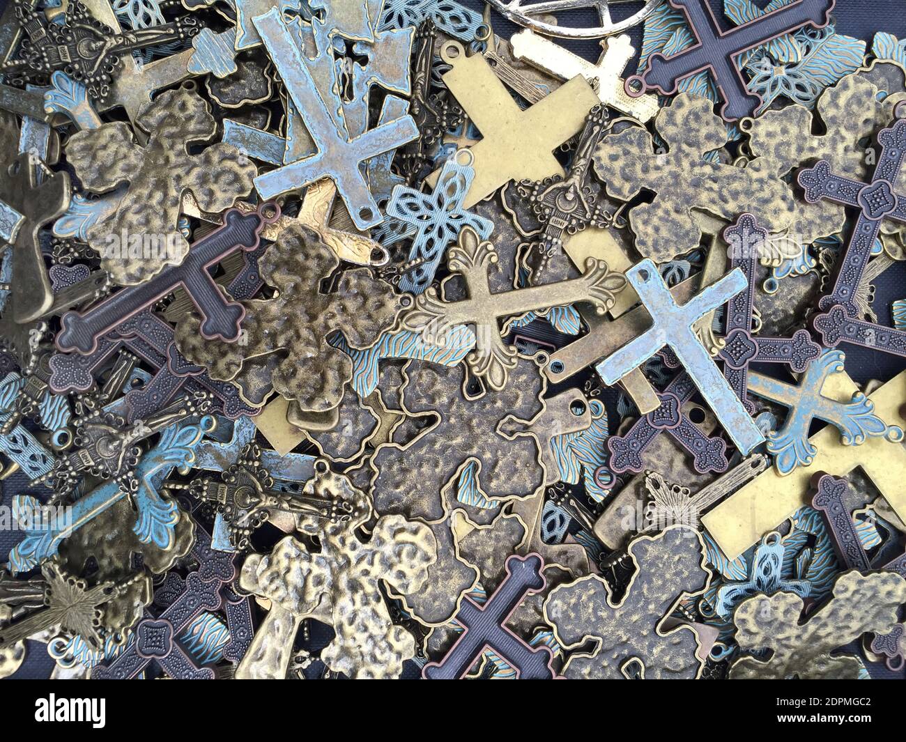 Una pila di crocifissi metallici di varie dimensioni e forme. Foto Stock