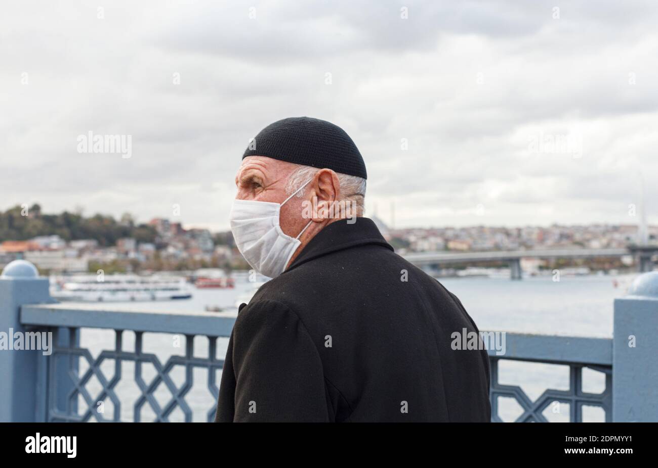 uomo musulmano che cammina sul ponte di Galata con il viso medico maschera Foto Stock