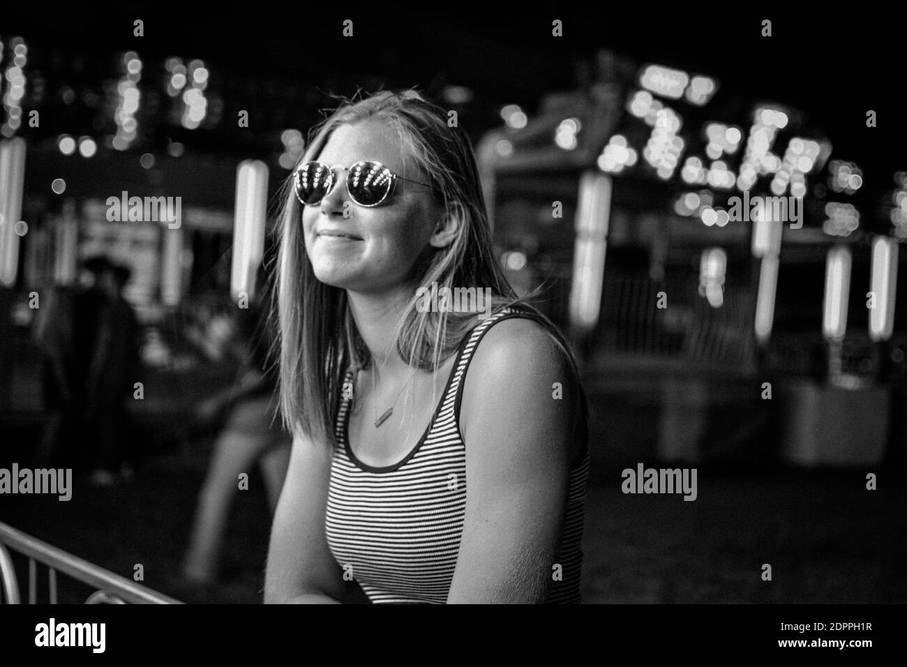 Giovane donna che indossa occhiali da sole in città di notte Foto stock -  Alamy
