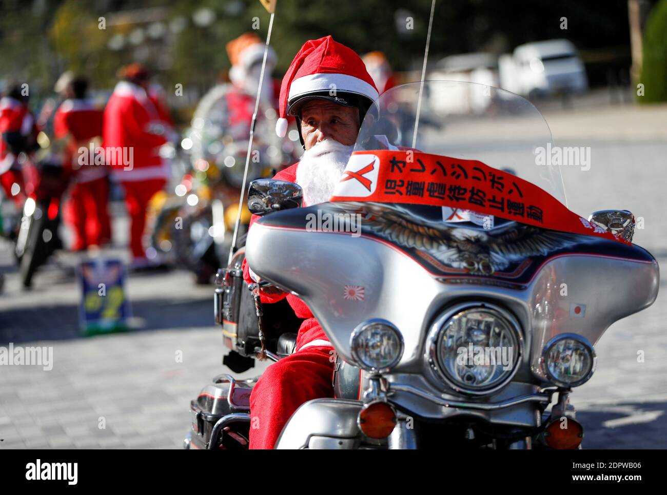 Un uomo vestito in costume di Babbo Natale cavalca la sua moto prima della  parata di Xmas Toy Run per rally up lo spirito di festa e rally contro  l'abuso di bambini,