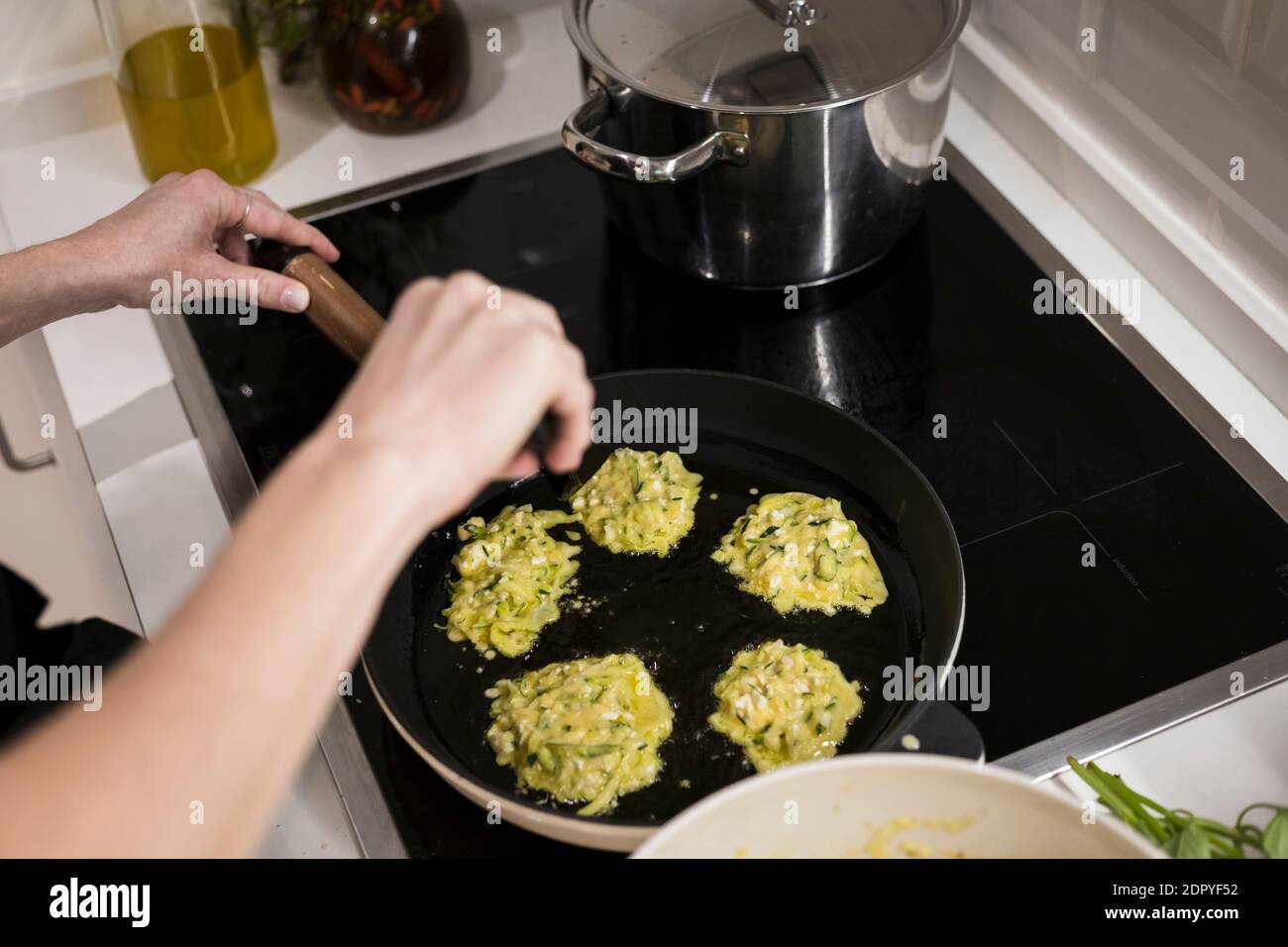 Giovane donna svedese di charme che cucina a casa nella sua cucina, preparando cibo mediterraneo sano per la sua famiglia. Blogger di cibo giovane facendo cibo prepar Foto Stock