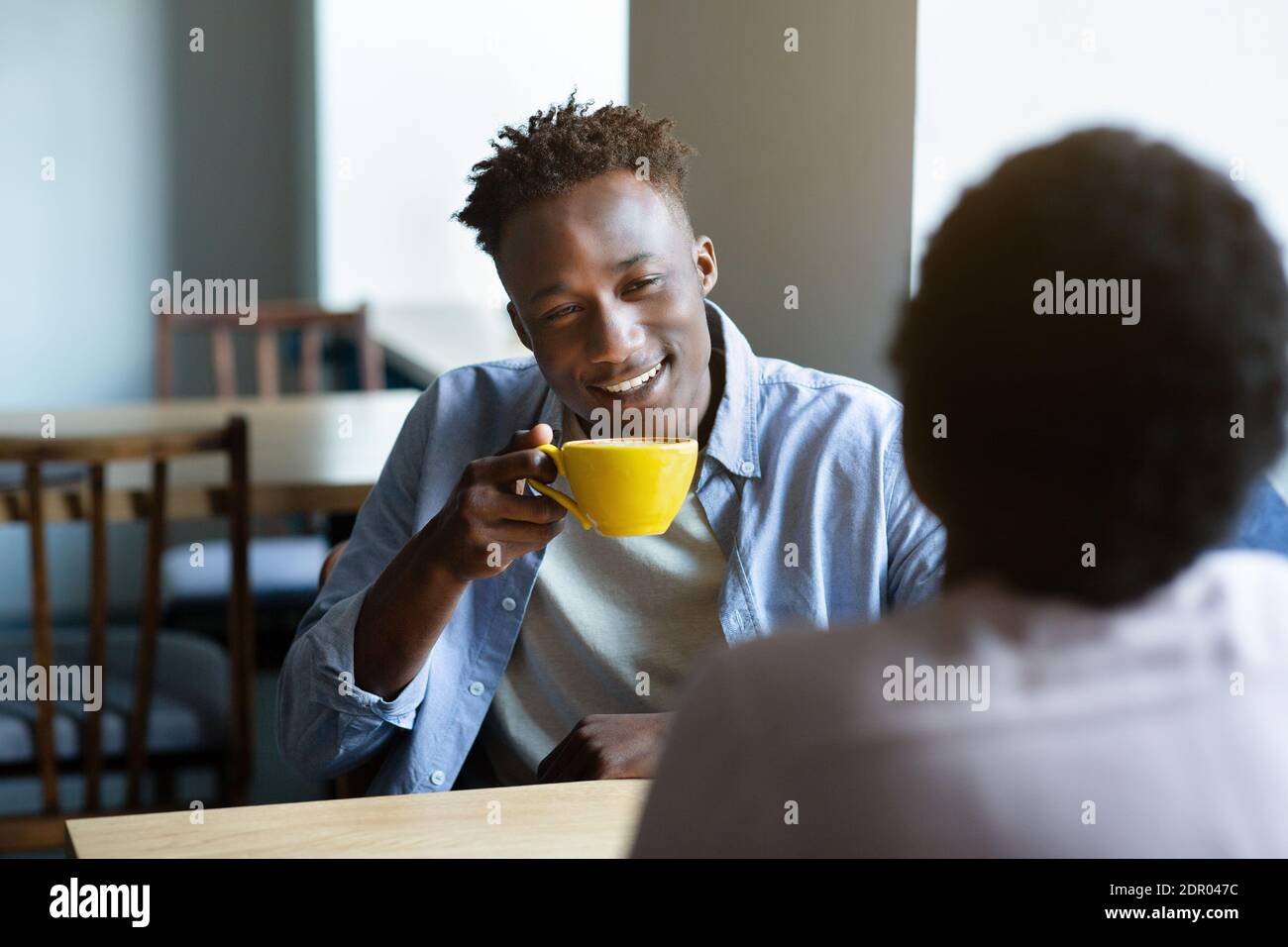 Adorabile coppia nera che chiacchiera nel bar a pranzo, avendo la prima data, iniziando una relazione romantica Foto Stock