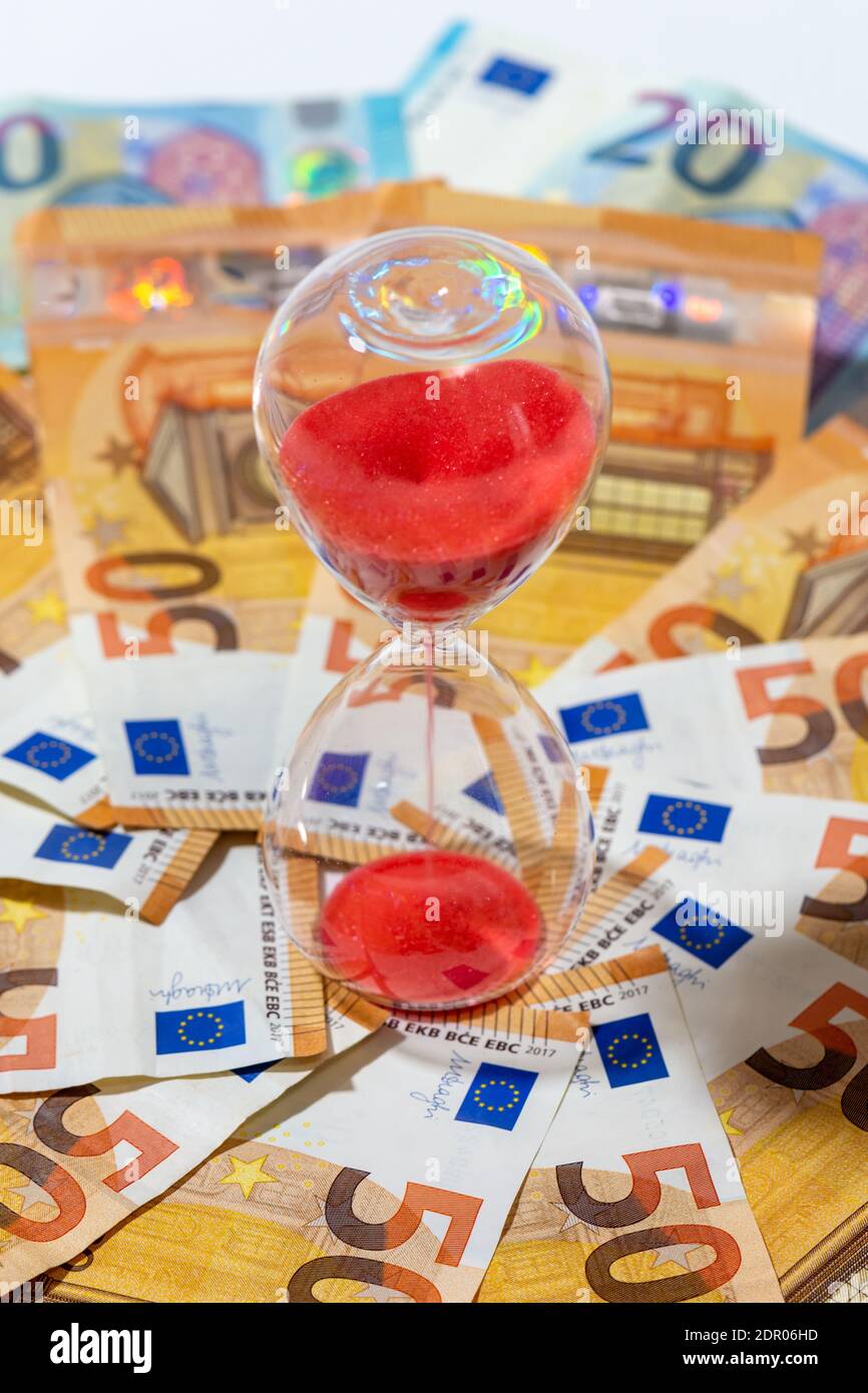 Clessidra su sfondo di banconote da 50 e 20 euro. Concetti di investimento, di redditività, di previdenza e di flusso di denaro nel tempo Foto Stock