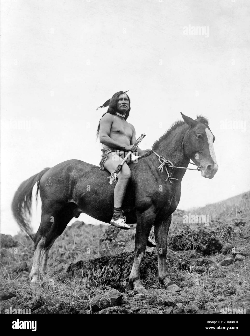 Fotografia d'epoca di un uomo Nez Percé, che indossa un panno di loin e mocassini, a cavallo. Fotografia storica di Edward S Curtis del 1907. Foto Stock