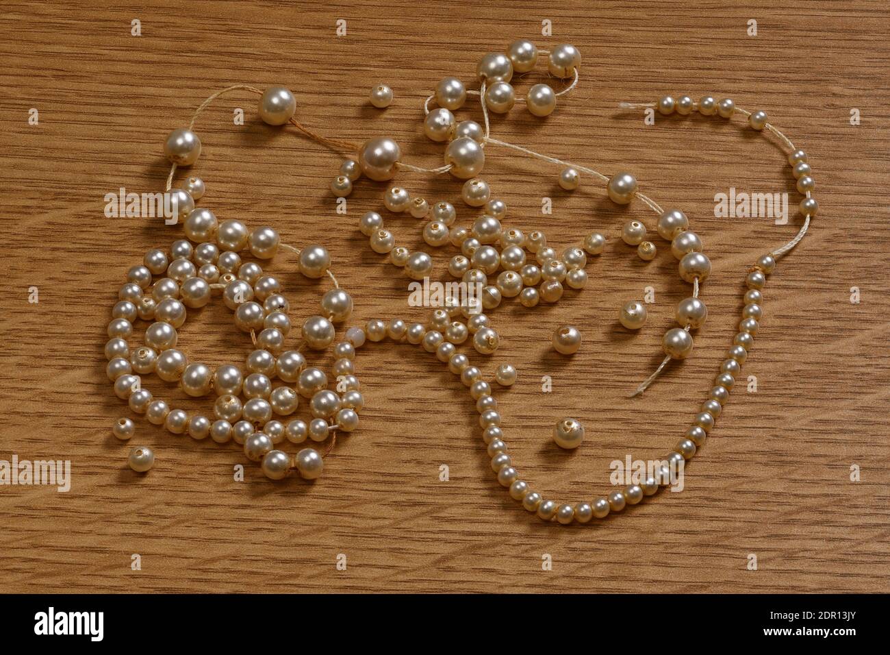 Una collana di perle spezzate di perle artificiali che ha bisogno di essere strappata Foto Stock
