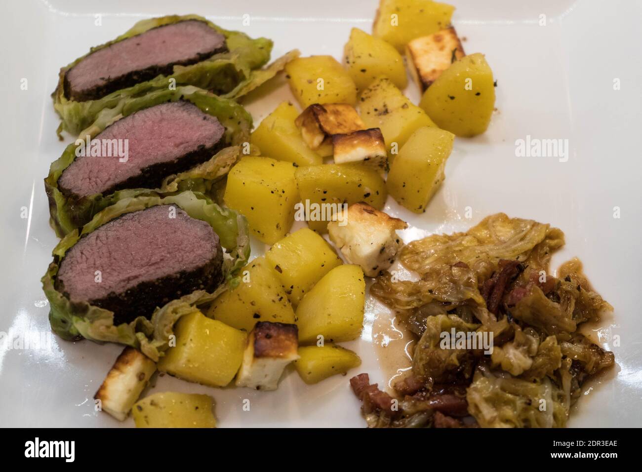 filetto di agnello finemente condito avvolto in foglie di cavolo sabaudo Foto Stock