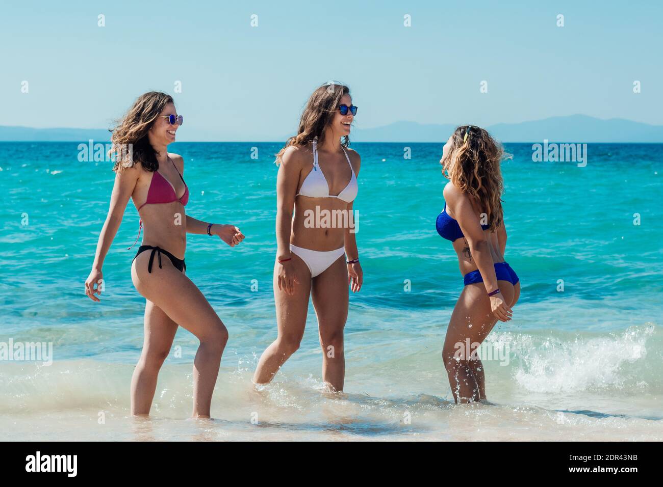 Le amiche in Bikini sorridono a Shore Foto stock - Alamy