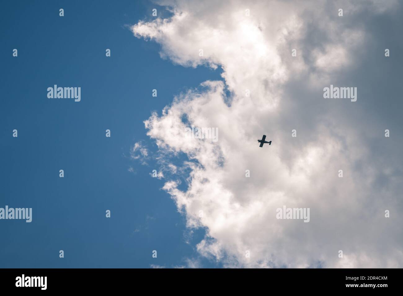 Silhouette aeroplano che vola nel cielo circondato da nuvola blu Foto Stock