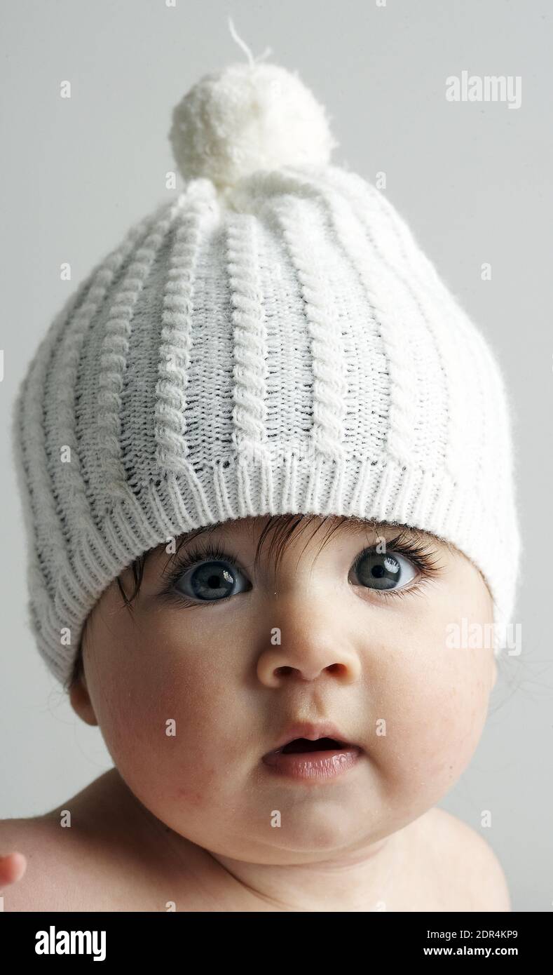 GRAN BRETAGNA / Inghilterra / Londra / Baby girl / 6-11 mesi /indossando maglia hat.on sfondo bianco Foto Stock
