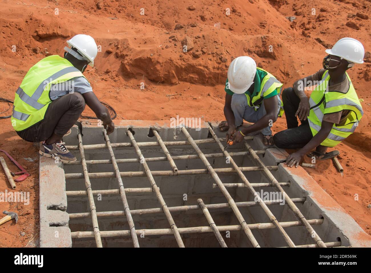 Lavoratori edili in Africa con dispositivi di protezione individuale Foto Stock