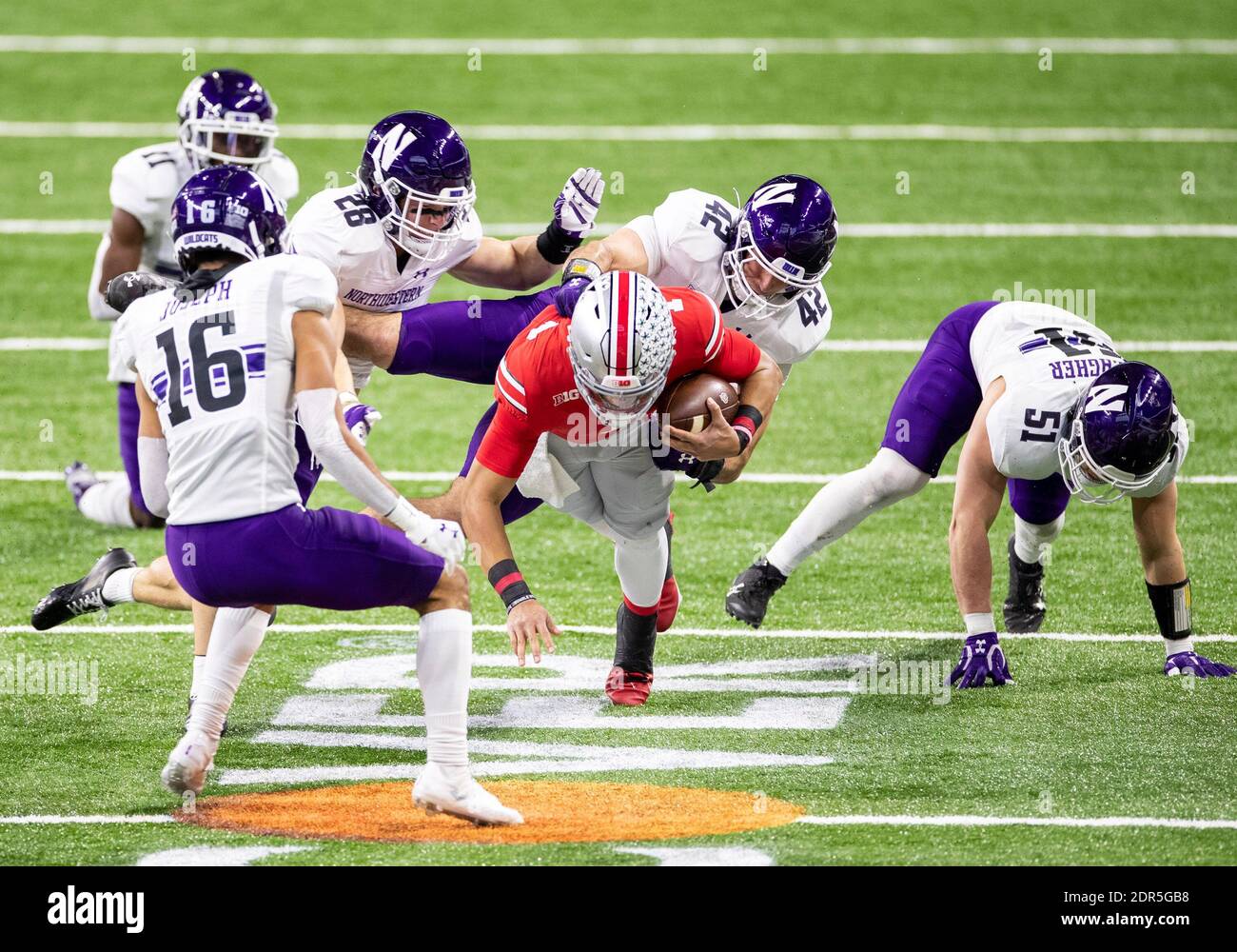 Indianapolis, Indiana, Stati Uniti. 19 dicembre 2020. Il linebacker nord-occidentale Paddy Fisher (42) fa il track su Justin Fields dello stato dell'Ohio (1) durante l'azione di gioco di NCAA Football tra i Northwestern Wildcats e l'Ohio state Buckeyes al Lucas Oil Stadium di Indianapolis, Indiana. L'Ohio state sconfisse il Northwestern 22-10. John Mersies/CSM/Alamy Live News Foto Stock