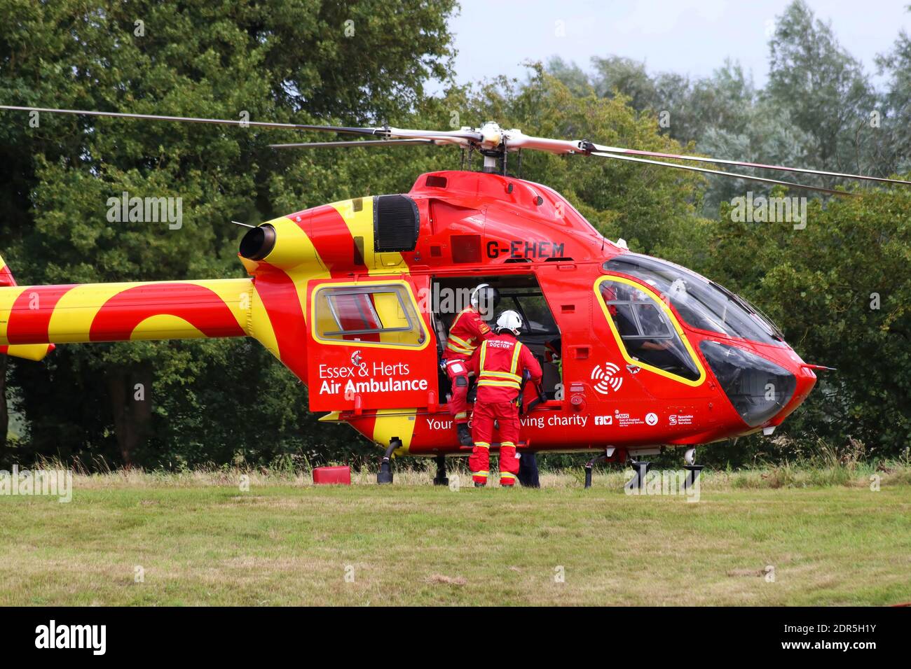 Essex e Herts Airambulance atterraggio in un campo per e soccorso di emergenza dopo un incidente Foto Stock