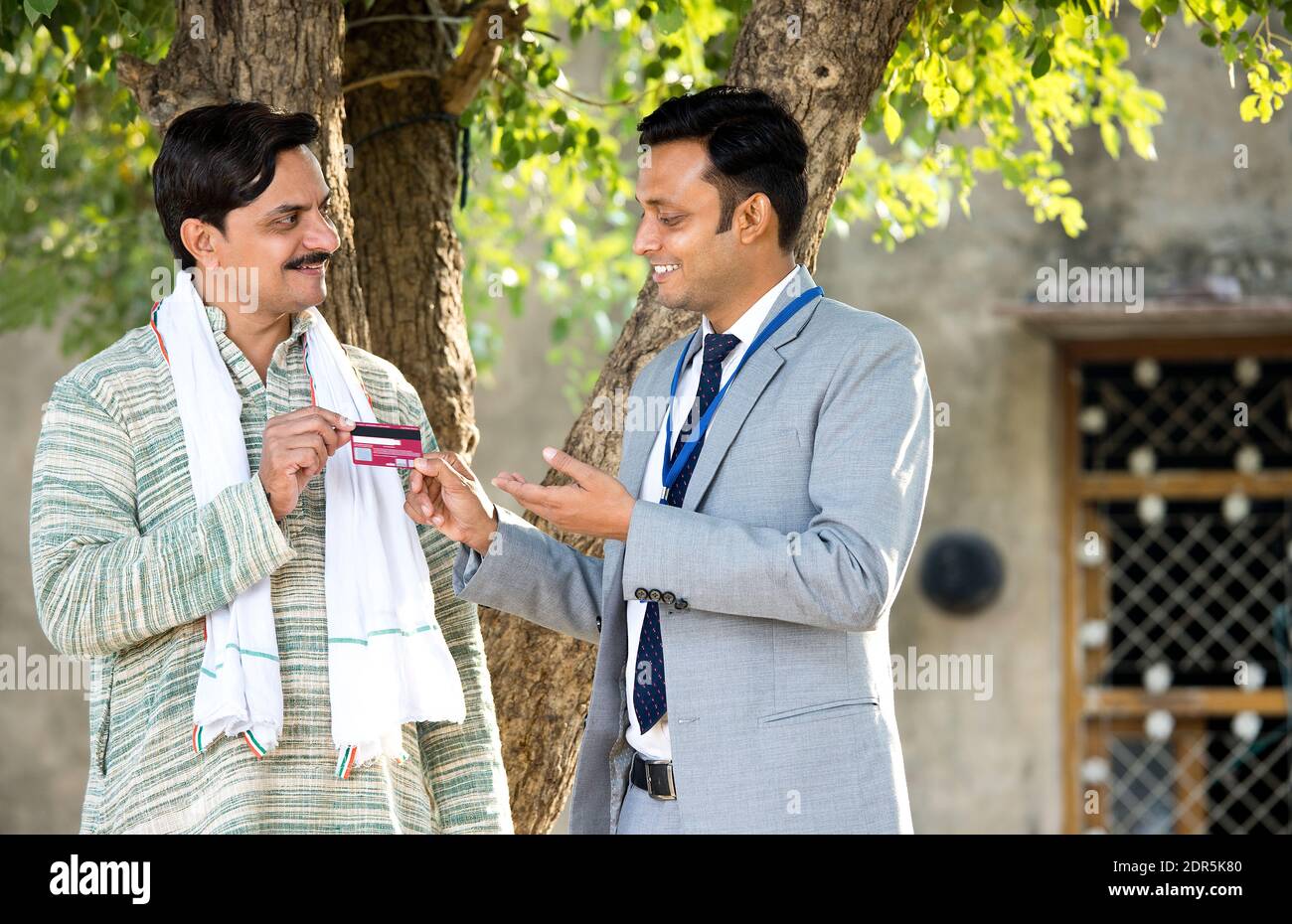 Dirigente rurale della banca indiana che dà la carta di credito al contadino del villaggio Foto Stock