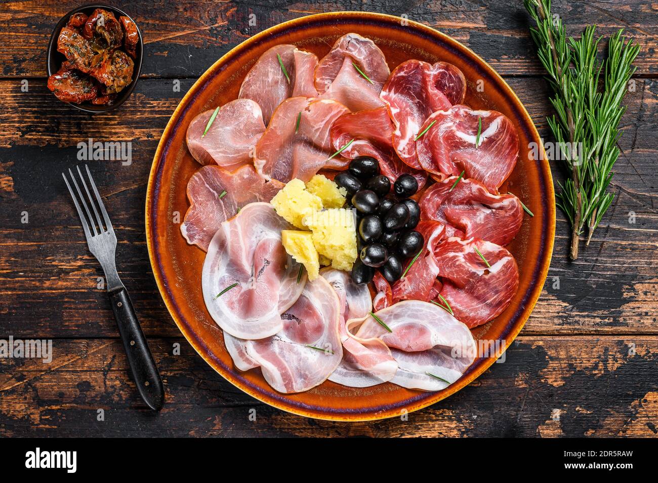 Piatto di carne italiana con prosciutto, bresaola, pancetta, salame e parmigiano. Sfondo di legno scuro. Vista dall'alto. Foto Stock