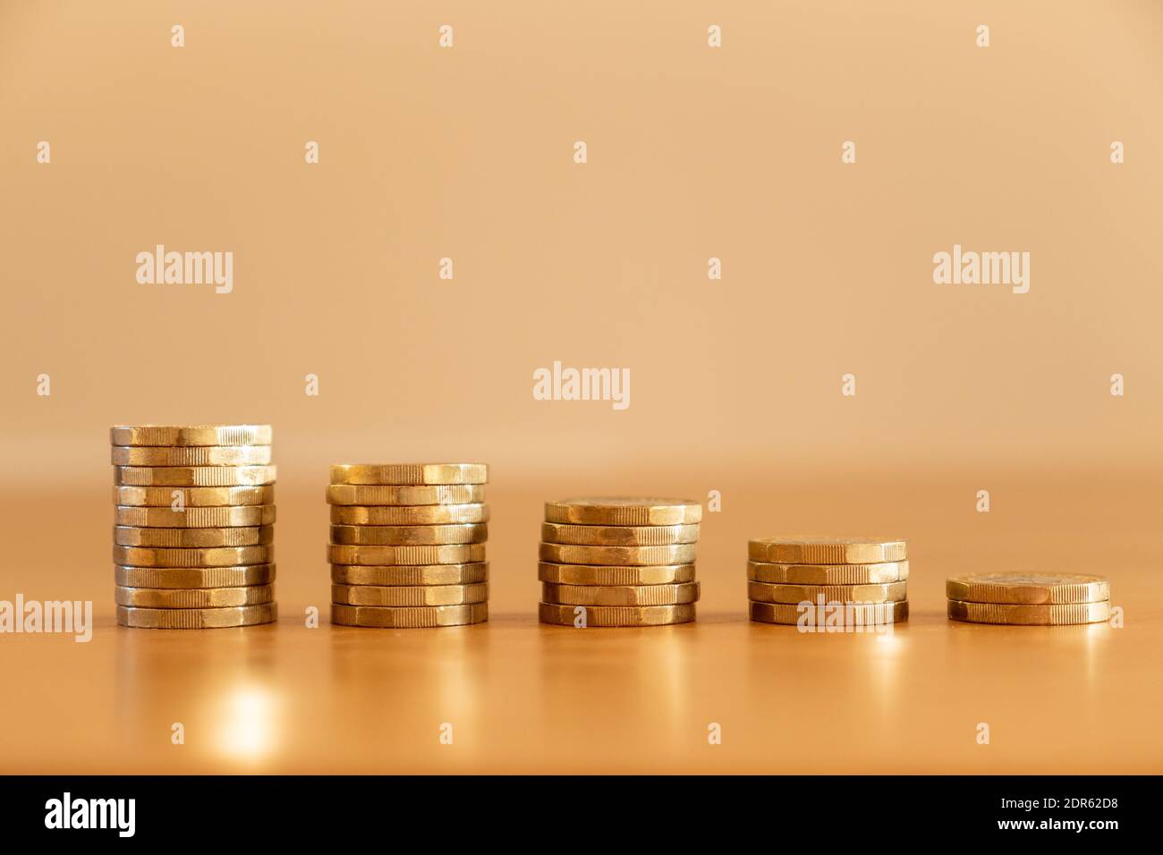 Primo piano di pile di molte monete sterline da una sterlina che diminuiscono di dimensioni come il denaro che scende a simboleggiare gli effetti dell'inflazione, Regno Unito Foto Stock