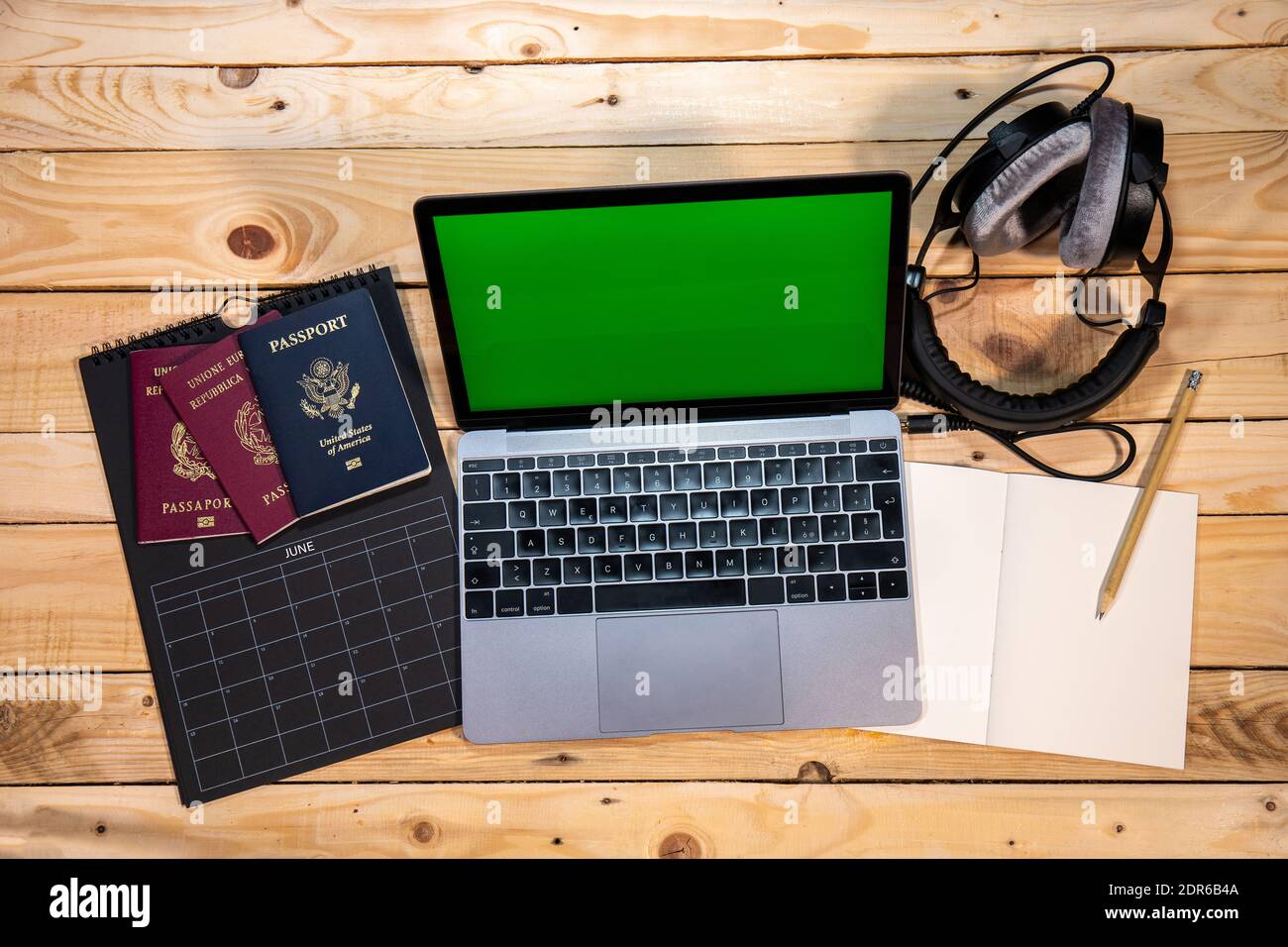 Pianificate la prossima vacanza estiva o un viaggio con i vostri amici. Calendario, passaporti italiani e statunitensi, computer, cuffie e notebook. Foto Stock