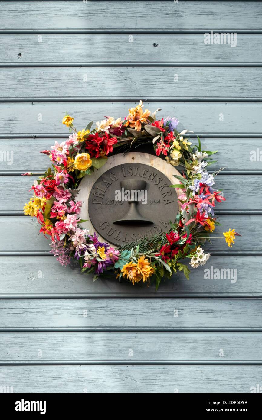 Placca rotonda con la corona dei fiori in UN edificio di Reykjavik L'Associazione dei Goldsmiti islandesi Foto Stock