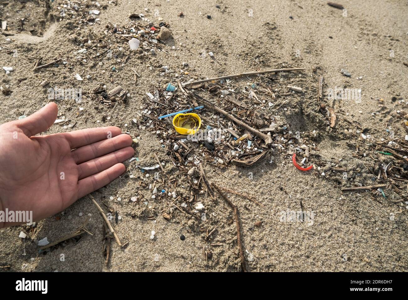 Uomo raccogliere rifiuti di micro plastica su ecosistema costa oceanica sporca, natura inquinamento Foto Stock