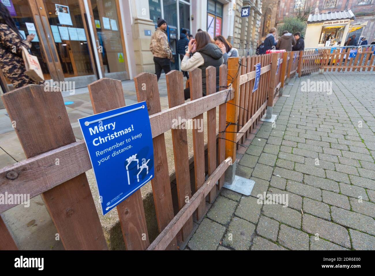 Segni di allontanamento sociale sulle recinzioni erette in St Ann's Square, Manchester, durante il dicembre 2020 mercatini di Natale e pandemia di coronavirus Foto Stock