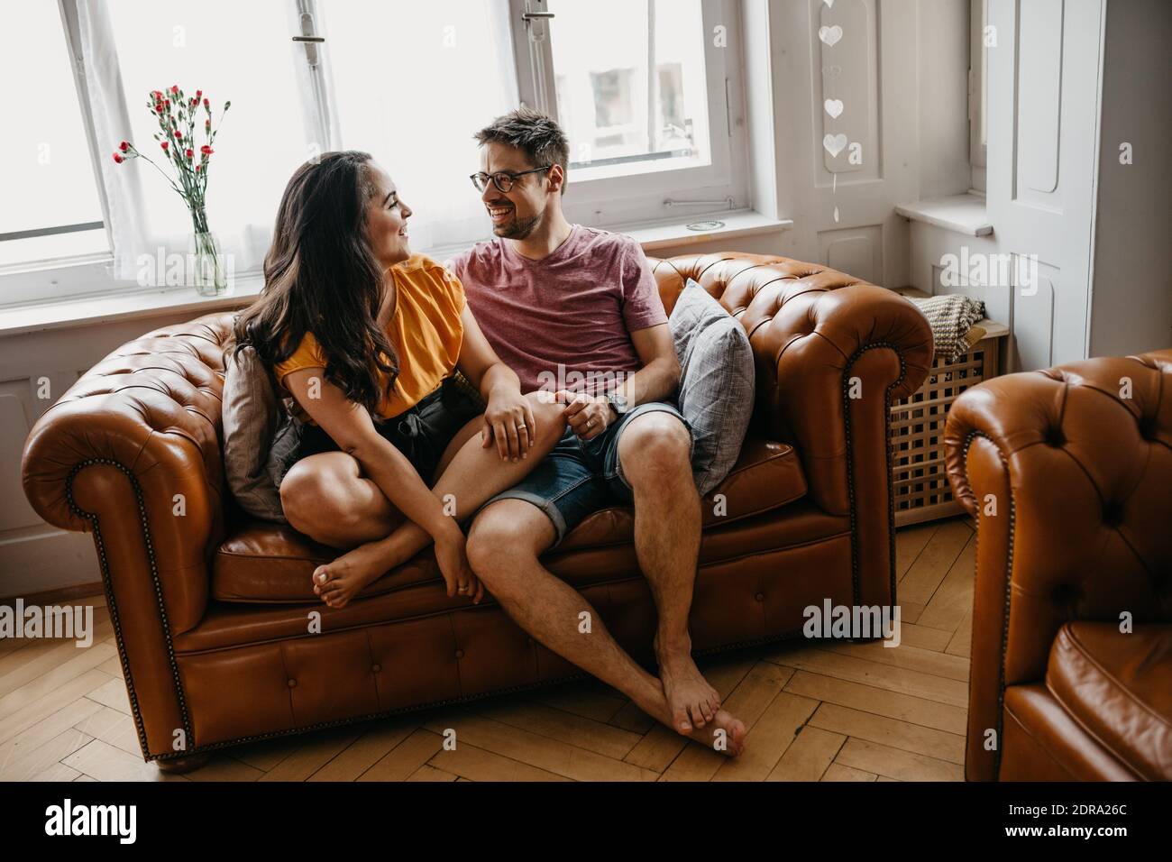 Giovane seduto sul divano di casa Foto stock - Alamy