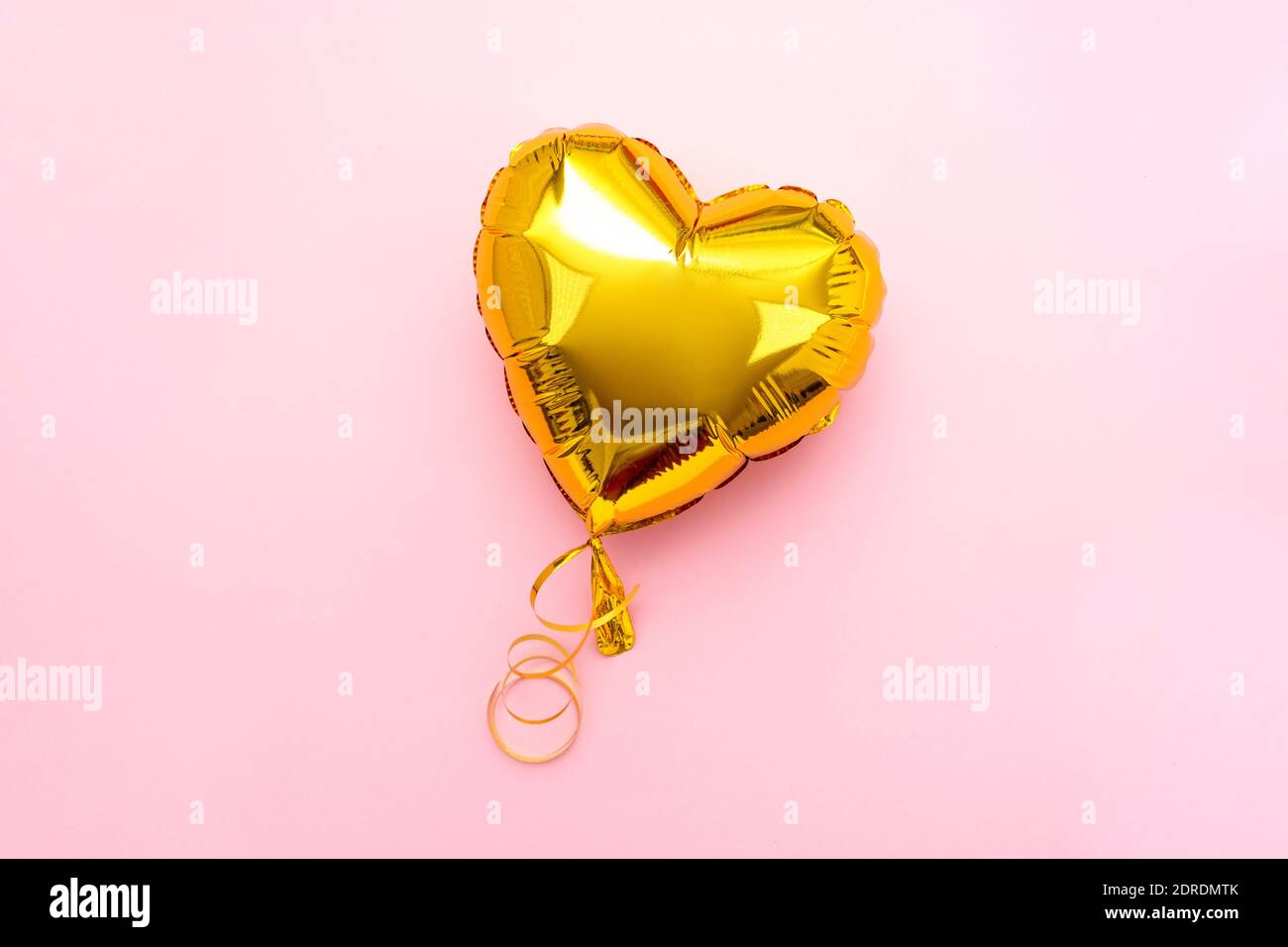 Golden Heart FOIL palloncino vista superiore su sfondo rosa San Valentino. CopySpace Foto Stock