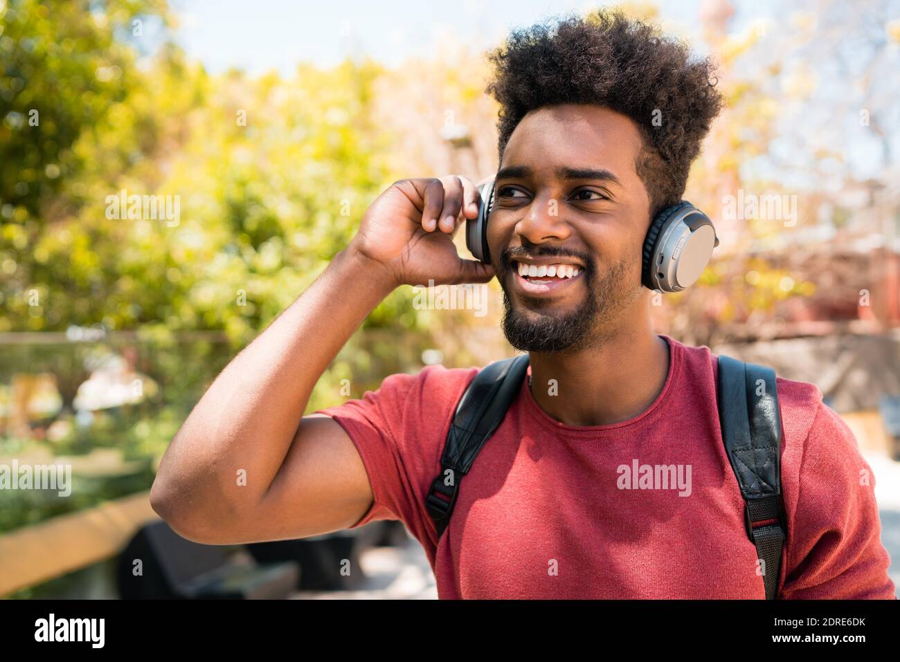 Giovane afro che ascolta la musica con le cuffie. Foto Stock