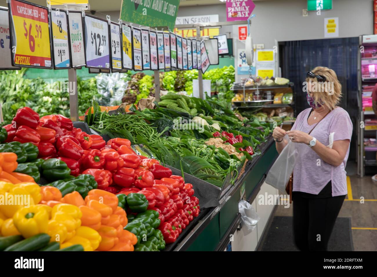 Modello rilasciato donna australiana indossare facemark come protezione covid 19 Negozio di alimentari nel supermercato Sydney per le verdure Foto Stock