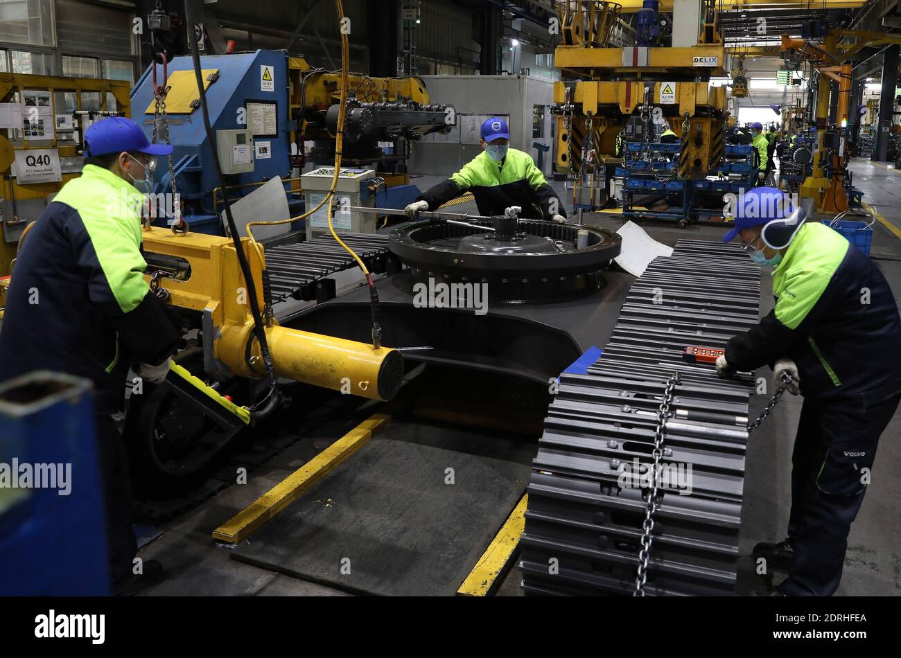 (201221) -- SHANGHAI, 21 dicembre 2020 (Xinhua) -- lavoratori installano un componente di trasmissione su un veicolo su una linea di produzione di escavatori presso la Volvo Construction Equipment (China) Co., Ltd. Nella Shanghai della Cina orientale, 17 dicembre 2020. Volvo Construction Equipment (Volvo CE), un produttore internazionale di attrezzature da costruzione, è entrato nel mercato cinese nel 2002, stabilendo la sua sede a Shanghai. Con l'epidemia di COVID-19 che rallenta lo slancio economico globale nel 2020, le multinazionali vedono promettenti opportunità in Cina mentre il paese continua ad approfondire la sua apertura- Foto Stock