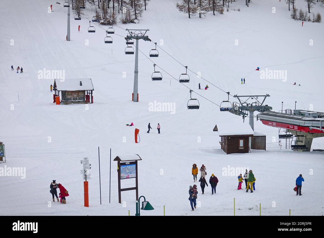 Piste da sci chiuse a causa della pandemia nel periodo natalizio, pochi turisti con bambini giocano sulla neve con le bob. Sestriere, Italia - Dicembre 2020 Foto Stock