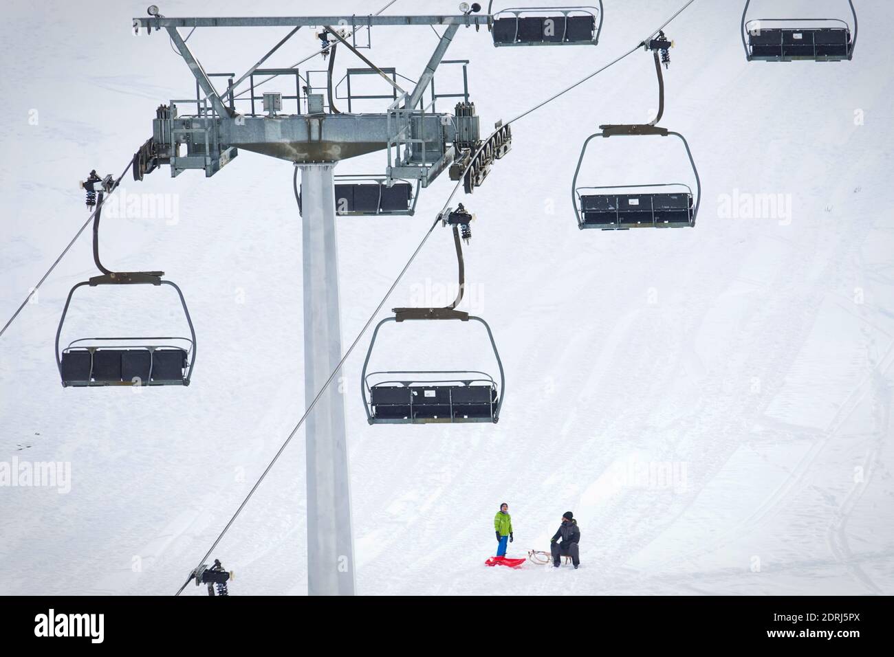 Piste da sci chiuse a causa della pandemia nel periodo natalizio, pochi turisti con bambini giocano sulla neve con le bob. Sestriere, Italia - Dicembre 2020 Foto Stock