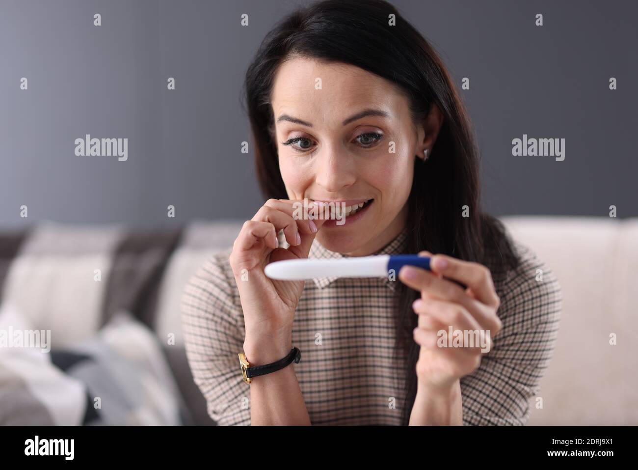 Donna sorpresa che guarda il closeup test di gravidanza Foto Stock