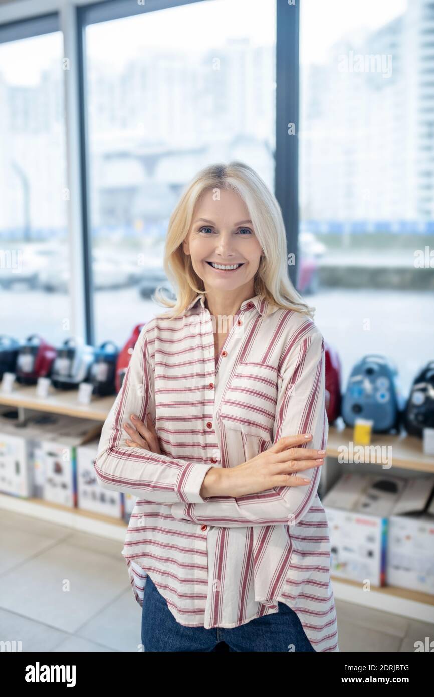 Bionda cliente femminile in piedi in uno showroom di beni di consumo Foto Stock