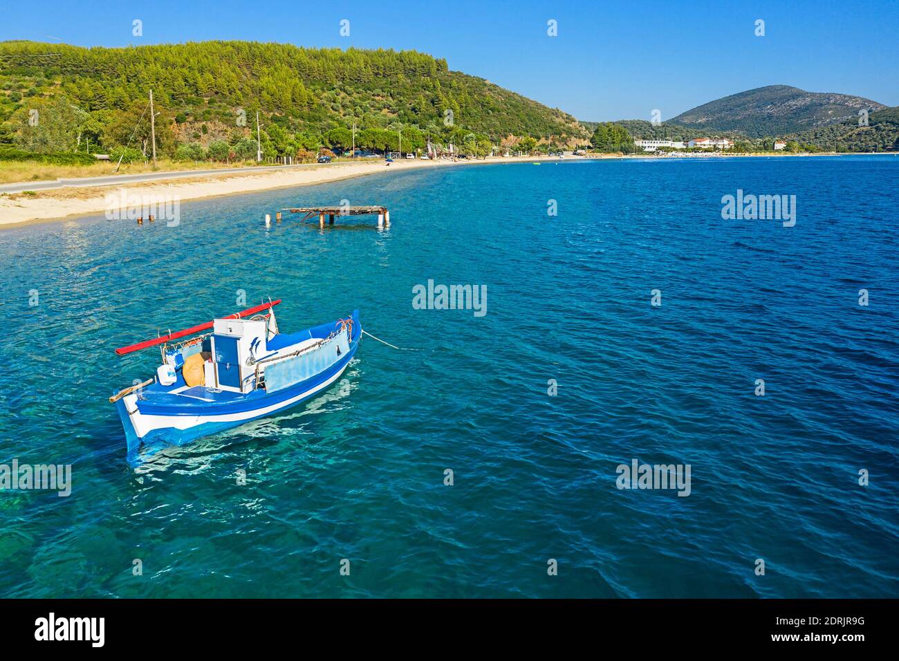 Panorama della costa mediterranea, Grecia, Halkidiki, Sithonia. Vista dall'alto della barca a vela in acqua blu, spiaggia di sabbia bianca, sfondo pineta Foto Stock