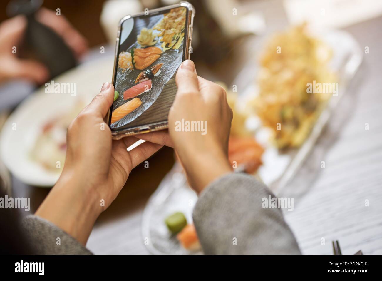 Foto ritagliata di fotografo di talento scattando una foto di meraviglioso sushi preparato dallo chef Foto Stock