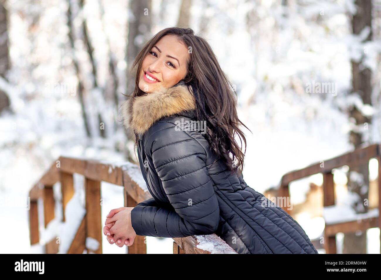 Giovane donna in posa in foresta innevata con cappotto caldo Foto Stock