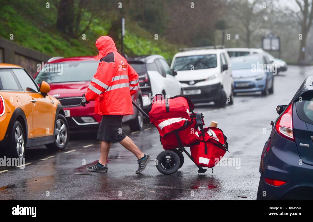 Brighton UK 21 dicembre 2020 - UN postino che consegna il post di Natale e pacchi a Brighton ancora indossando i suoi shorts nonostante la pioggia e il vento oggi: Credit Simon Dack / Alamy Live News Foto Stock
