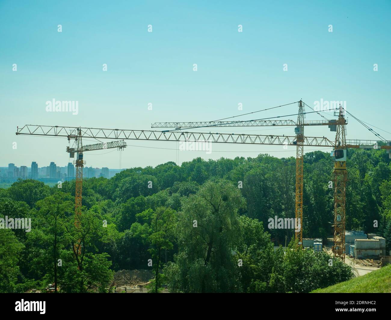 Gru di costruzione alla periferia della città. Distruzione di foreste per costruzione. Foto Stock